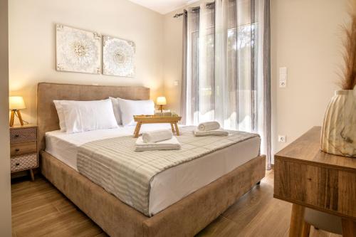 - une chambre avec un grand lit et une fenêtre dans l'établissement George Luxury Beach House, à Aiándion