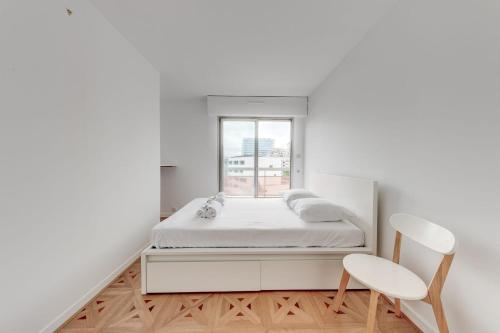 biała sypialnia z łóżkiem i oknem w obiekcie Grand app lumineux proche défense w mieście Courbevoie