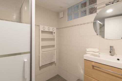 een witte badkamer met een wastafel en een spiegel bij Maison familiale avec jardin in Pornic