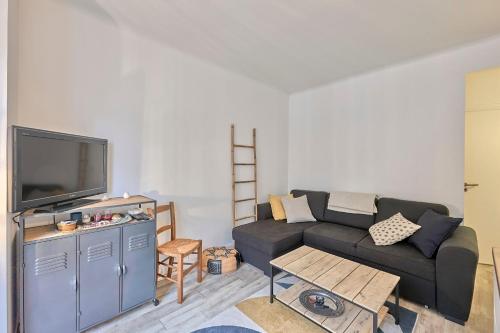 a living room with a couch and a tv at L'Augustine - Appartement dans le 15e in Paris