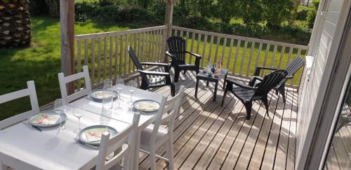 une table et des chaises blanches sur une terrasse dans l'établissement LE PETIT COIN DE PARADIS, à Roscanvel