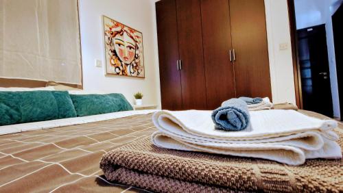 Habitación con 1 cama con toallas en el suelo en Blue Pearl holiday apartments with pool in kato paphos, en Pafos