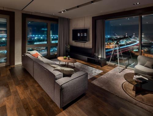 a living room with a couch and a tv at b'mine Hotel Frankfurt Airport in Frankfurt/Main