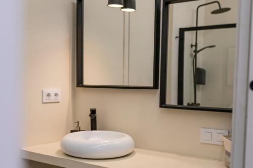 a bathroom with a white sink and a mirror at Resolana Suites in Seville