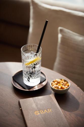 a drink on a table next to a bowl of nuts at C-Hotels Silt in Middelkerke