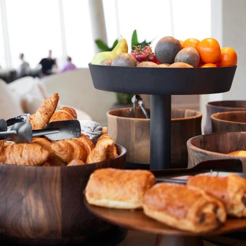 a tray of breads and fruit on a table at C-Hotels Silt in Middelkerke