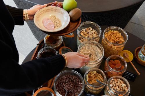 a woman preparing food on a table with bowls of food at C-Hotels Silt in Middelkerke
