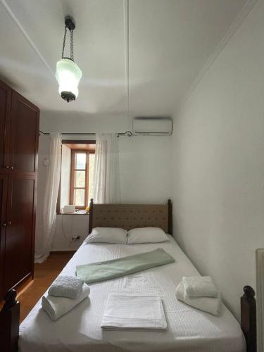 a bedroom with a bed with two towels on it at ΠΟΛΥΞΕΝΗ -ΕΚΑΒΗ in Kondiás