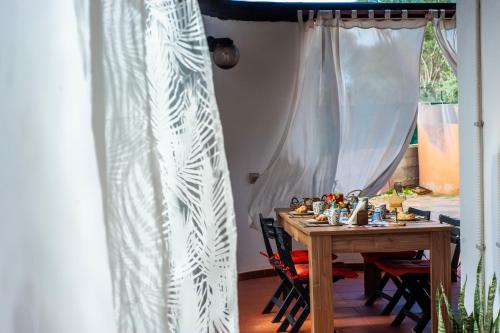 a dining room table with chairs and a curtain at Sardinia Del Sud in Porto Columbu - Perdʼe Sali