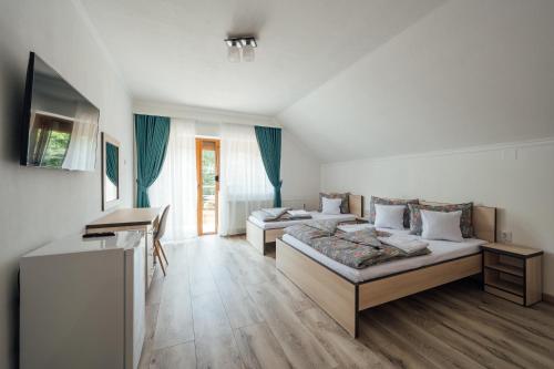 a room with two beds and a desk in it at Sándor Panzió 2 in Praid