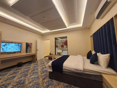 Habitación de hotel con cama y TV de pantalla plana. en سلافا للشقق أبها en Abha