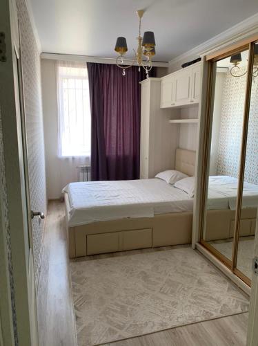 um pequeno quarto com uma cama e uma janela em мкр Юбилейный 39, 2-х комнатная квартира Люкс класса, район Kostanay plaza, Allur Auto от Home Hotel em Qostanay