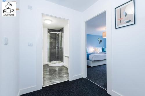 Zimmer mit einem Schlafzimmer mit einem Bett und einem Spiegel in der Unterkunft Luxurious 1-Bedroom Apartment, Sleeps 4, Free Parking in Manchester
