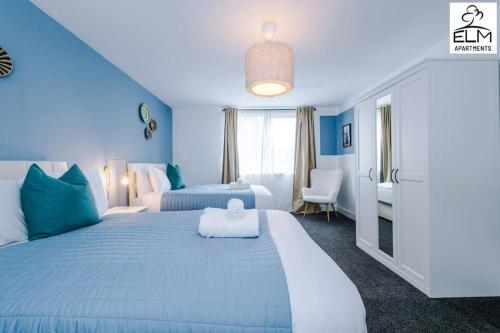 ein blaues Schlafzimmer mit einem großen Bett mit blauen Wänden in der Unterkunft Luxurious 1-Bedroom Apartment, Sleeps 4, Free Parking in Manchester