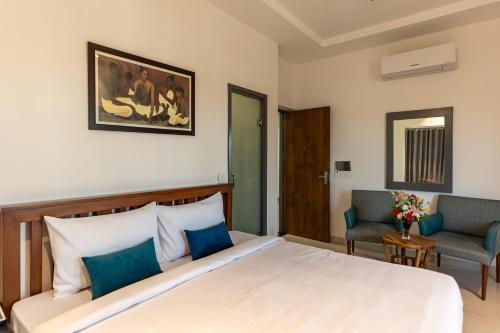 um quarto de hotel com uma cama e uma cadeira em Blessings Inn em Amritsar