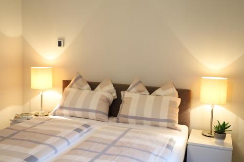 a bedroom with a bed with pillows and two lamps at Casa QUATTRO FIUMI in Tegna