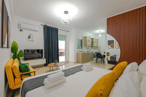 a bedroom with a large bed and a living room at Sunny Apts in Sarandë