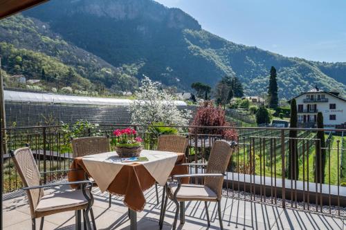 Una mesa y sillas en un balcón con vista. en Haus Rosengarten Apt D, en Terlano
