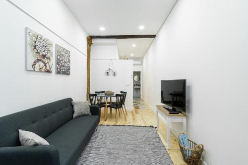 sala de estar con sofá y comedor en Casas da Ferraria by 4U Alojamento - Tonho da Chica & Avô Marchão, en Abrantes
