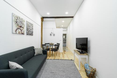 a living room with a couch and a dining room at Casas da Ferraria by 4U Alojamento in Abrantes