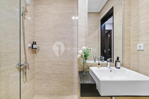 a bathroom with a sink and a glass shower at Sepia By Kozystay - MACAN Museum - Kebon Jeruk in Jakarta