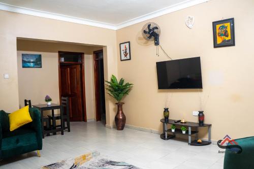 a living room with a flat screen tv on the wall at Kica Apartment with Airconditioned bedrooms in Lira, Uganda in Lira