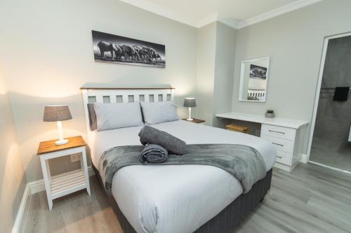 a bedroom with a large white bed and a table at 9 On Oak Luxury One Bedroom in Gqeberha