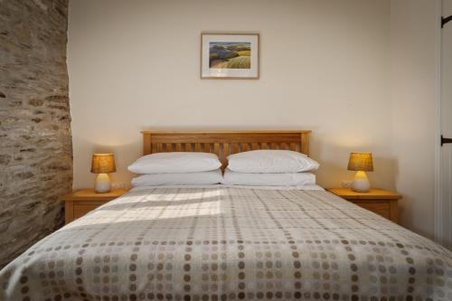 a bedroom with a large bed with two lamps at Penpedwast Upper Barn Newport, Pembrokeshire in Eglwyswrw