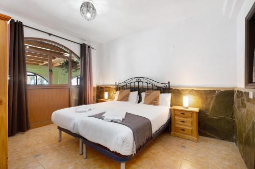 een slaapkamer met een groot bed en een nachtkastje bij Villa Duke in San Miguel de Abona