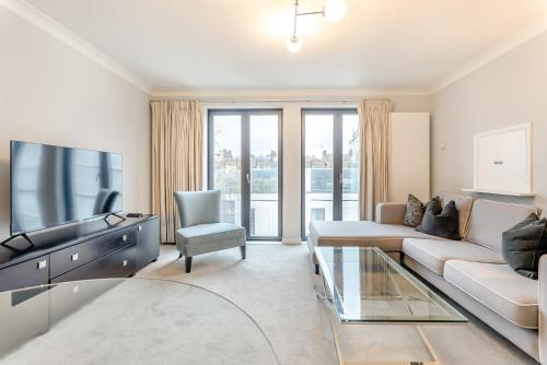 a living room with a couch and a tv at Pond Place Apartments in London