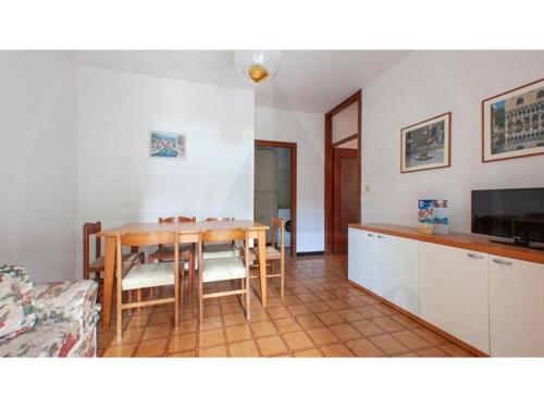 cocina y comedor con mesa de madera en Villa Verde, en Eraclea Mare