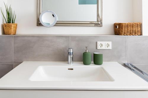 a white sink in a bathroom with a mirror at Ferienwohnung Waldrose in Waging am See
