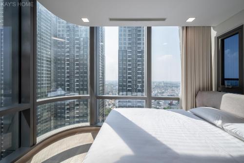 a bedroom with a white bed and large windows at Landmark 81 President Suite - Vinhome Central Park in Ho Chi Minh City