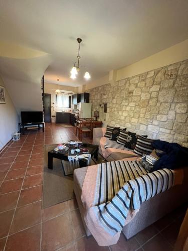 ein Wohnzimmer mit 2 Sofas und einer Steinmauer in der Unterkunft Afytos house in Afytos