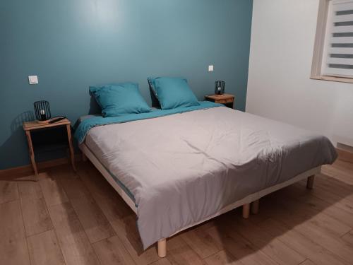 a bed in a bedroom with blue walls at Du panier au gite in Vouziers