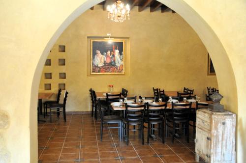 un comedor con mesas, sillas y una pintura en El Beyt Farmhotel, en Az Zabū