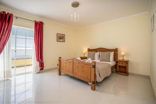 a bedroom with a bed and a large window at Casa da Amoreira in Alvor