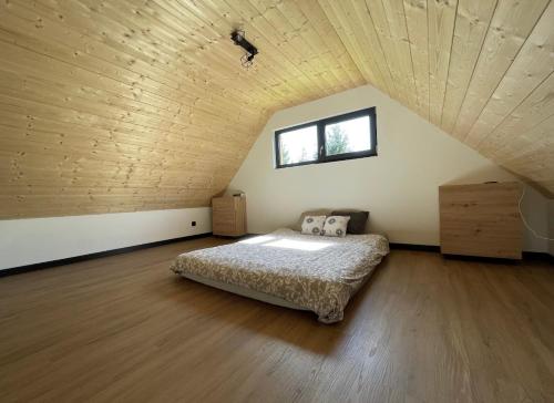 1 dormitorio con cama y techo de madera en Dom na Pojezierzu Łęczyńsko - Włodawskim, en Ludwin