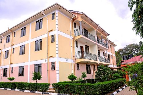 an apartment building with balconies and trees at AKELLO HOTEL in Soroti