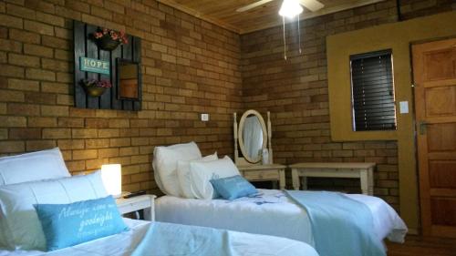 a bedroom with two beds and a mirror at Magnolia Guesthouse & coffeeshop in Vaalpark