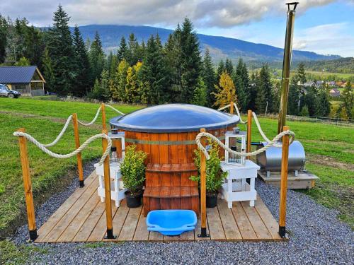 una terraza de madera con cenador y barril en Domek w górach Tiny House Forest Jacuzzi/widoki, en Lipnica Wielka