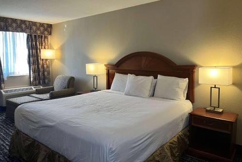 ein Hotelzimmer mit einem großen Bett und zwei Lampen in der Unterkunft Baymont by Wyndham Indianapolis South in Indianapolis