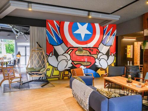 a room with a wall with a mural of a cartoon at Mercure Reims Parc Des Expositions in Reims