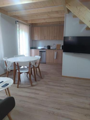 uma cozinha e sala de jantar com mesa e cadeiras em Drewniany domek wakacyjny em Człuchów