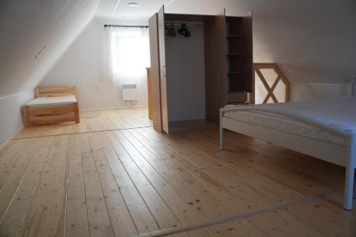 1 dormitorio con 1 cama y suelo de madera en Drewniany domek wakacyjny, en Czluchów