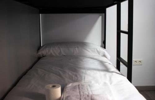 una cama con un rollo de papel higiénico al lado en Be Happy Hostel, en Nerja