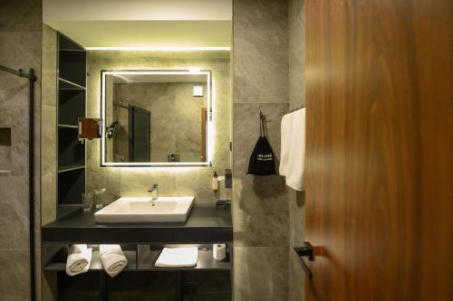 a bathroom with a sink and a mirror at Hotel Macedonia Square in Skopje