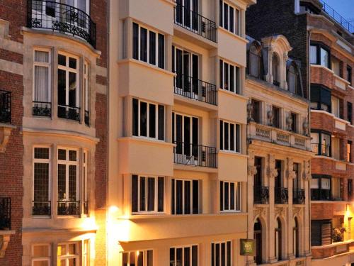 een hoog appartementencomplex met lichten aan bij ibis Styles Lille Centre Grand Place in Lille