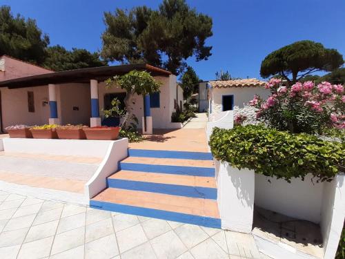 ein Haus mit blauen und weißen Treppen und Blumen in der Unterkunft Villaggio Marina Del Capo Capo Vaticano in Ricadi
