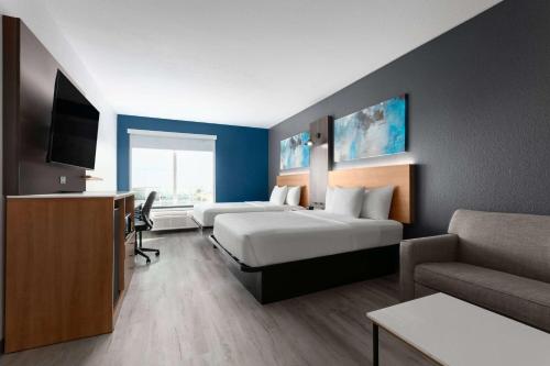 a hotel room with two beds and a couch at La Quinta Inn & Suites by Wyndham Ft Worth-Burleson in Burleson